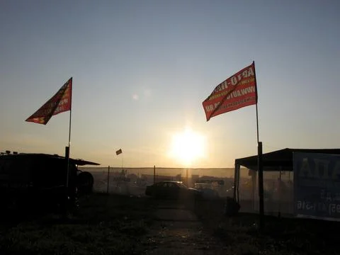 The sun sets behind the flags of Bangkok. Stock Photos