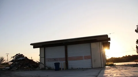 Sun sets behind garage and trash dump Stock Footage 95112783