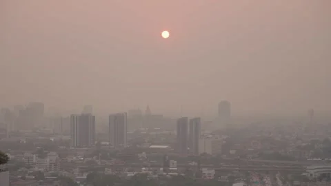 The sun sets behind the hazy skyline of Bangkok, shrouded in fog and pollution. Stock Footage 308492025