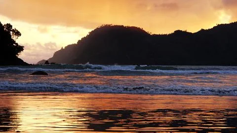 The sun sets behind the hills Stock Photos