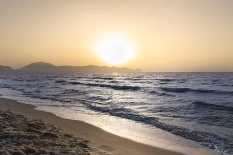 Sun sets behind the mountains in the background. Sunset on the island of Sicily. Stock Photos