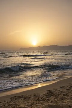 Sun sets behind the mountains in the background. Beautiful orange sunset Stock Photos