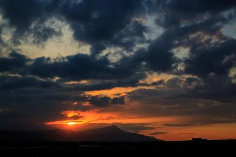The sun sets behind the mountains. beautiful panorama and view of the setting Stock Photos