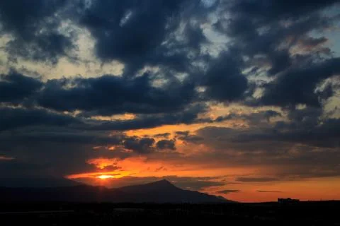 The sun sets behind the mountains. beautiful panorama and view of the setting Stock Photos