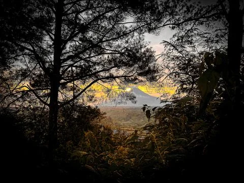 The sun sets behind the mountains Stock Photos