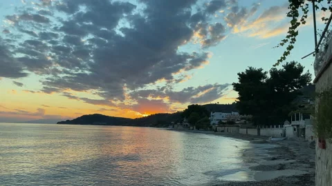 The sun sets behind the mountains on the shores Stock Footage 220547774
