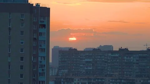 The sun sets behind residential multi-storey panel houses in a residential area. Stock Photos