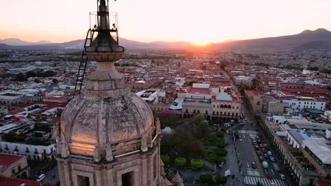 Sun sets behind a tower of the cathedral in Morelia, Mexico. 動画素材 172508162