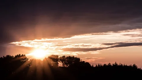 Sun sets behind trees while thunderstorm rolls in (4K Timelapse) 스톡 동영상 113873939
