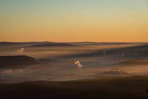 The sun sets below the horizon and illuminates Stock Photos