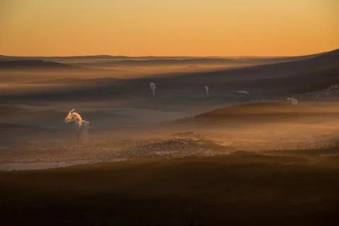 The sun sets below the horizon and illuminates Stock Photos