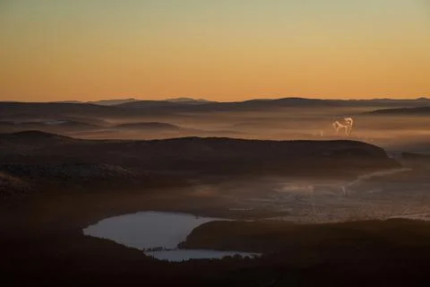 The sun sets below the horizon and illuminates Stock Photos