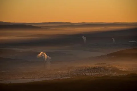 The sun sets below the horizon and illuminates Stock Photos