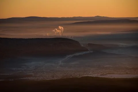 The sun sets below the horizon and illuminates Stock Photos