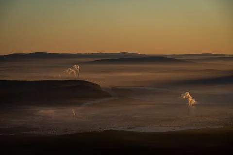 The sun sets below the horizon and illuminates Stock Photos