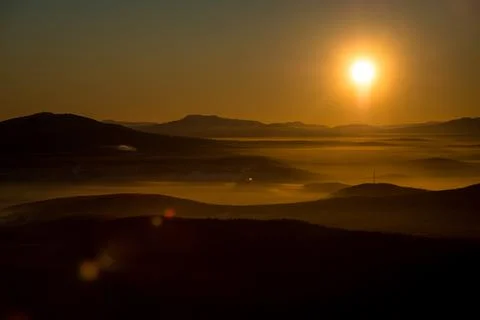 The sun sets below the horizon Stock Photos