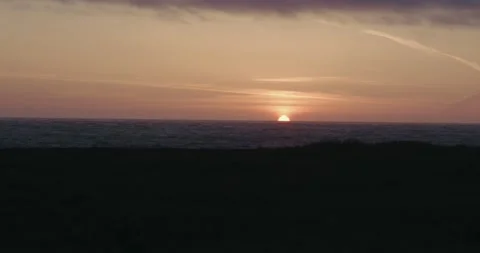 The sun sets below the ocean horizon Stock Footage 329279377