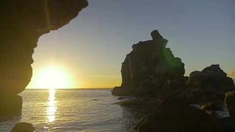 The sun sets between the rocks of a beach ,in the Philippines Stock Footage 235512316
