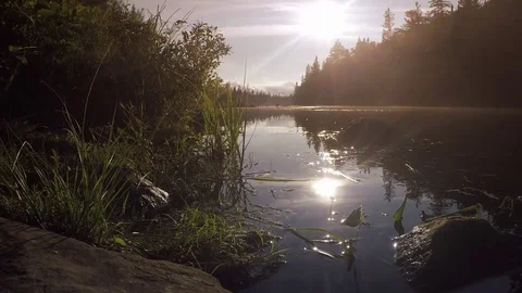 The sun sets as canoes paddle away in the distance Stock Footage 81919977