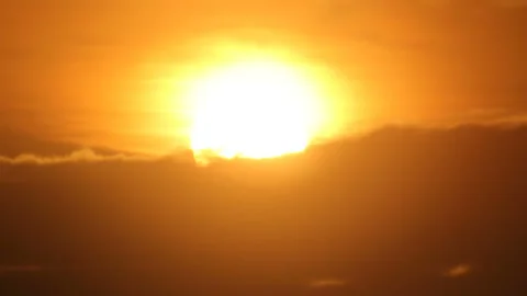 Sun sets into clouds Stock Footage 90001784