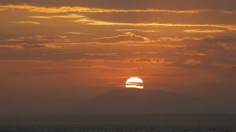 The sun sets directly to the mountain peak. Spectacular sky. Timelapse. Stock Footage 45296500