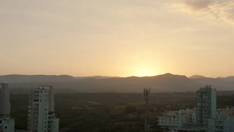 Sun sets down behind the mountain, cityscape on the background of the mountains Stock Footage 307591432