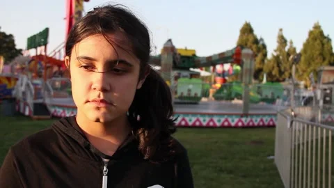 Sun sets on girl's face at deserted carnival Stock Footage 154940926