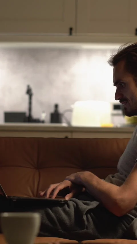 As the sun sets, a man finds solace on his cozy couch in a serene atmosphere Stock Footage 293146864