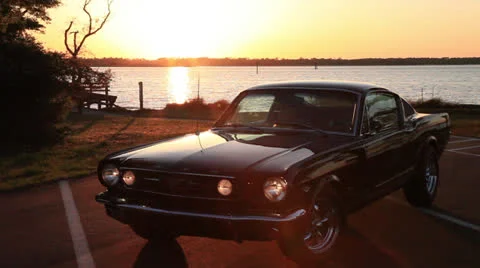 Sun sets on Mustang, ferry passes on waterway, 2000% Stock Footage 24587487