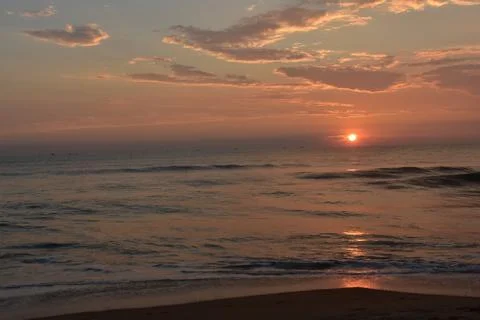 Sun sets in the ocean with beautiful sky Stock Photos