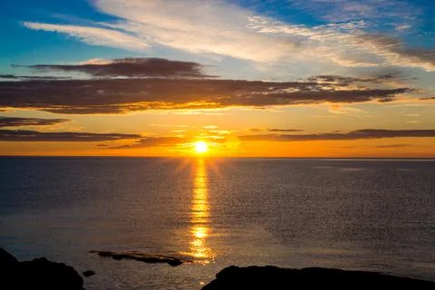 The sun sets into the ocean Stock Photos