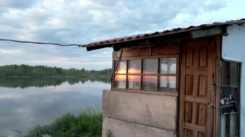 The sun sets outside the windows of the coastal house Stock Footage 196822144