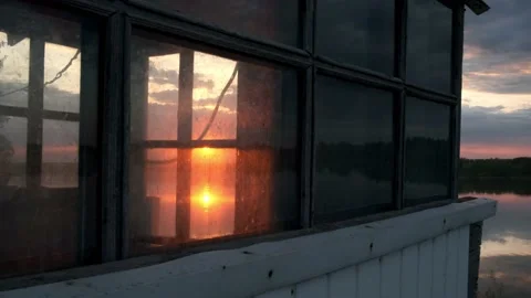 The sun sets outside the windows of the coastal house Stock Footage 196822147