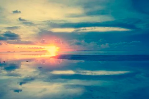 The sun sets over beach with beautiful reflection vintage style Stock Photos