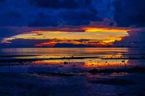 The sun sets over beach with beautiful reflection Stock Photos