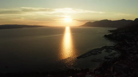 The sun sets over calm Adriatic Sea with reflection in Baska Voda, Croatia Video stock 345726962