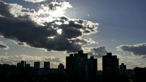 The sun sets over the city behind the clouds. Vídeo Stock 126567027