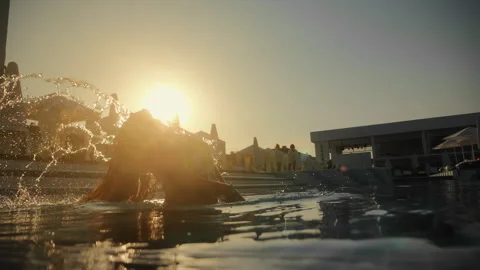 The sun sets over the horizon, illuminating the water near the pool where a Stock Footage 291962004
