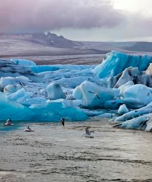The sun sets over icebergs floating in the famous glacier lagoon at Jokulsarlon Stock Photos