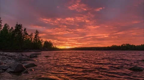 The sun sets over the lake forming a red sunset.  Stock Footage 64476239