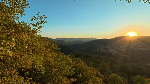 Sun sets over layered hills, golden light glows. Boracki krs Serbia 動画素材 345005778
