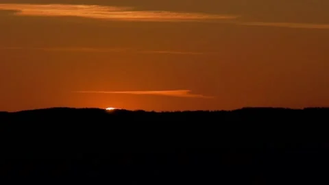 The sun sets over the mountain horizon at sunset Stock Footage 98397317