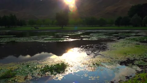 The sun sets over the mountains and is reflected in the lake Stock Footage 131773574