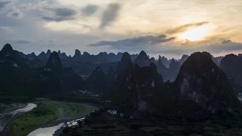 The sun sets over mountains and a river in a scenic landscape view Stock Footage 312304185