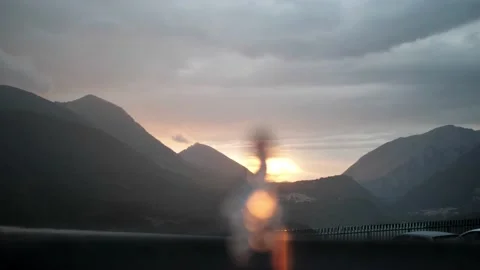 The sun sets over the mountains, the sunset in the foreground is a defocused Video stock 144889736