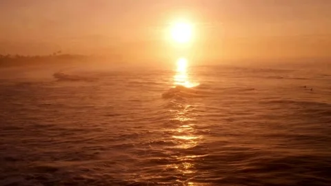 The sun sets over the ocean, casting a golden light on the water 스톡 동영상 312677713