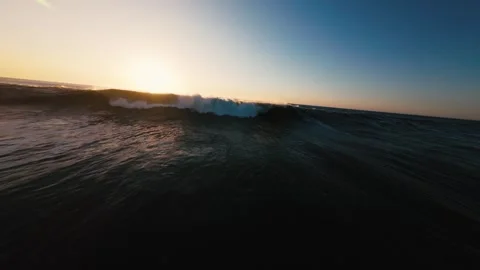 Sun sets over ocean, waves crash, foam swirls Stock Footage 339788891