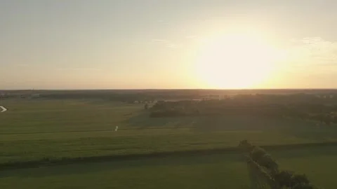 The sun sets over a patchwork of green fields and forests Video stock 293158202