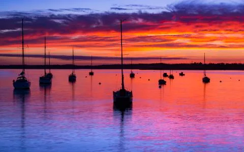 The Sun sets over Poole Harbour in Dorset at Hamworthy pier jetty Foto stock