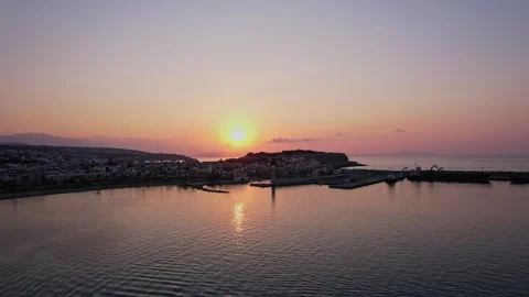 The sun sets over a tranquil harbor, casting warm hues across the water Stock Footage 287039745